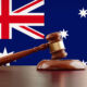Wooden gavel in front of Australian flag. The gavel is nicely textured and it is casting soft shadows on the ground. Great use for law, justice and auction related concepts.
